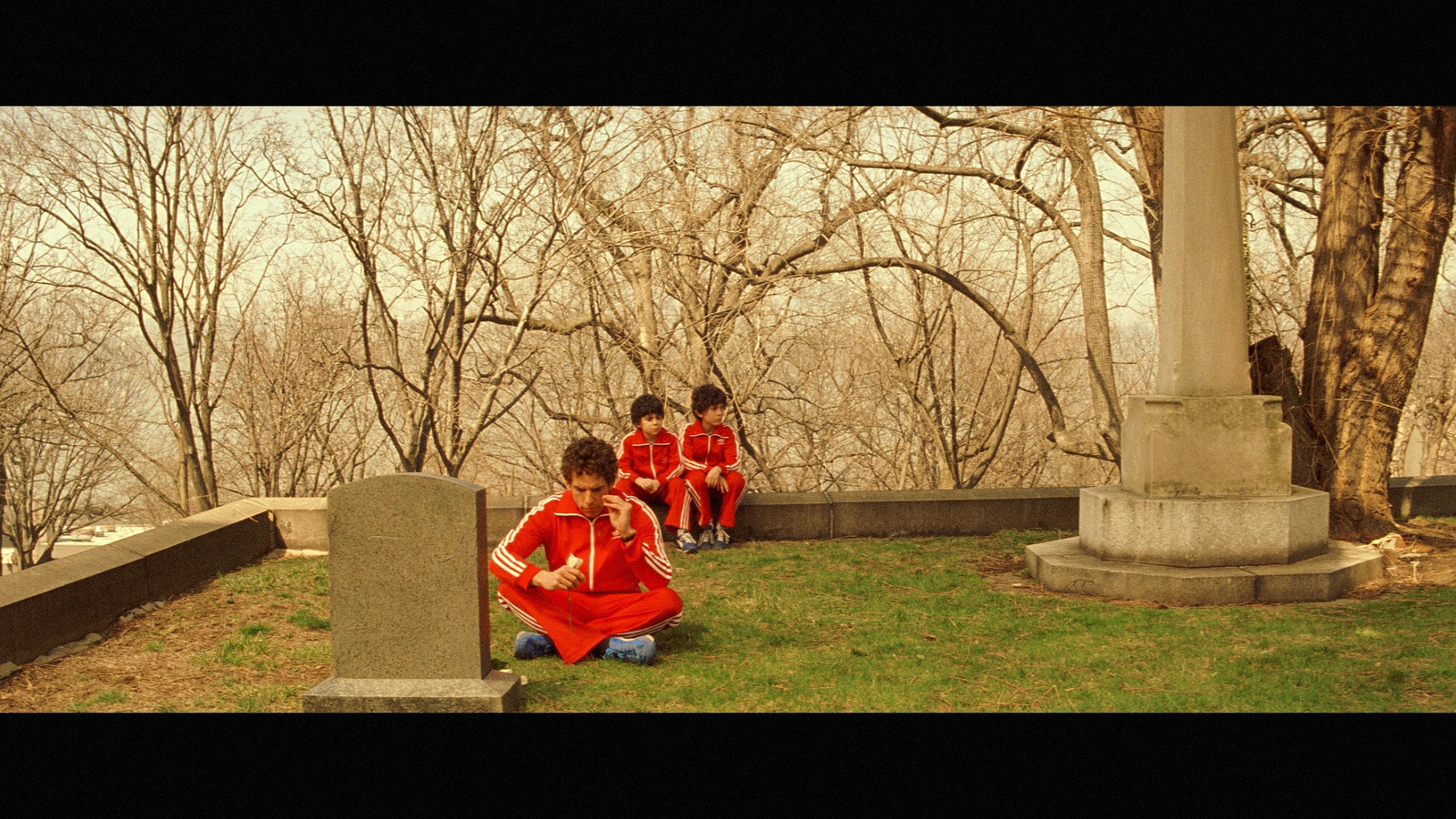 a group of children in red uniforms sitting on the ground