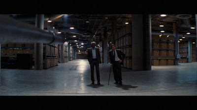 a couple of men standing next to each other in a warehouse