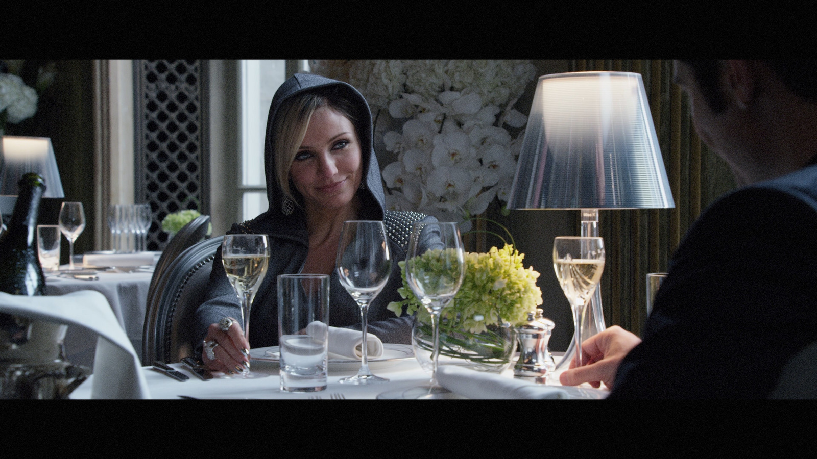 a woman sitting at a table with wine glasses