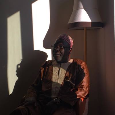 a man sitting in a chair next to a lamp