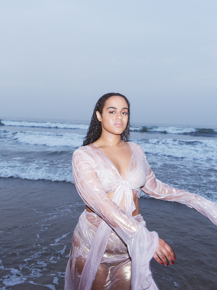 a woman in a wet suit standing in the ocean