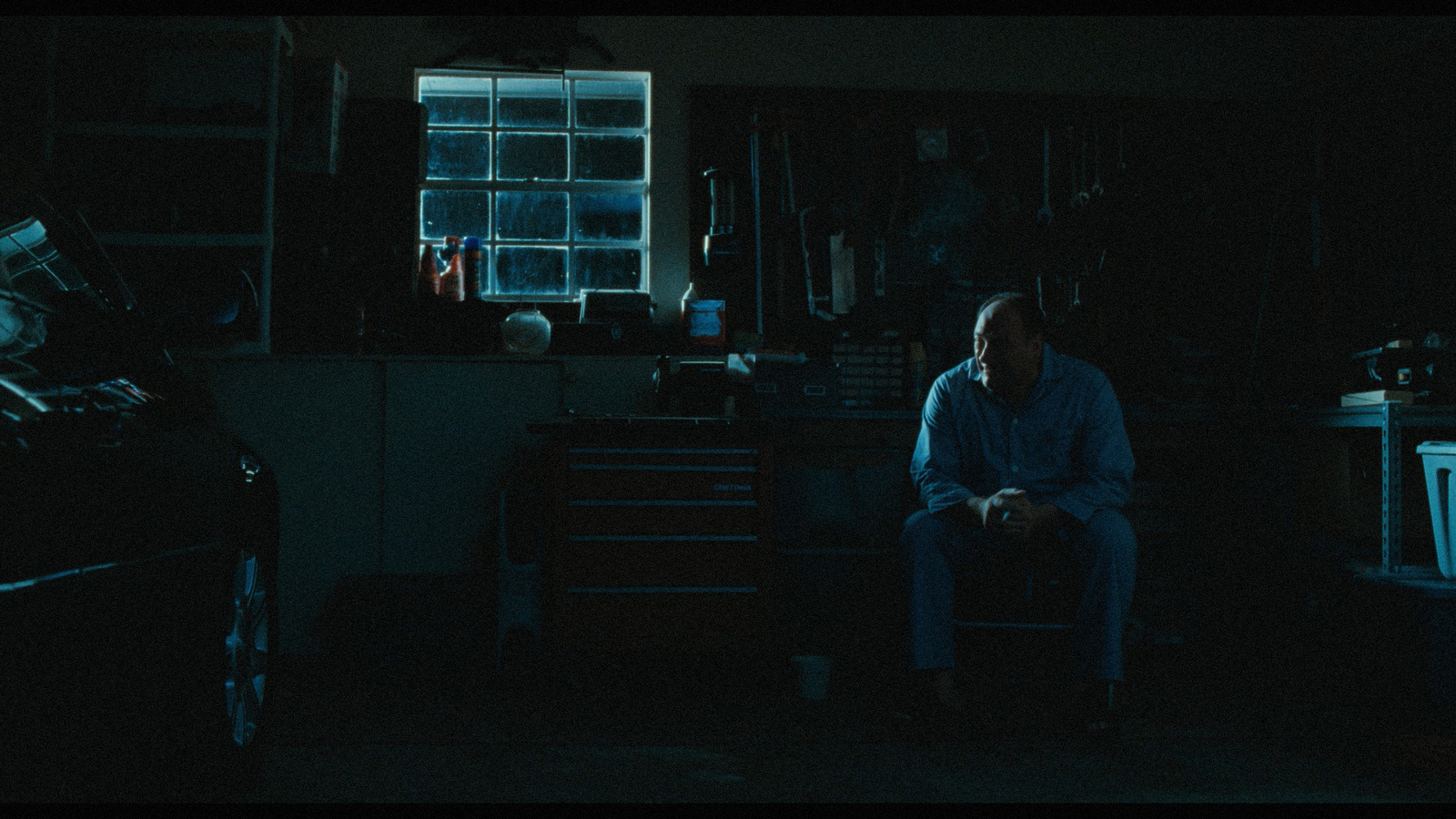 a man sitting in a dark room in the dark