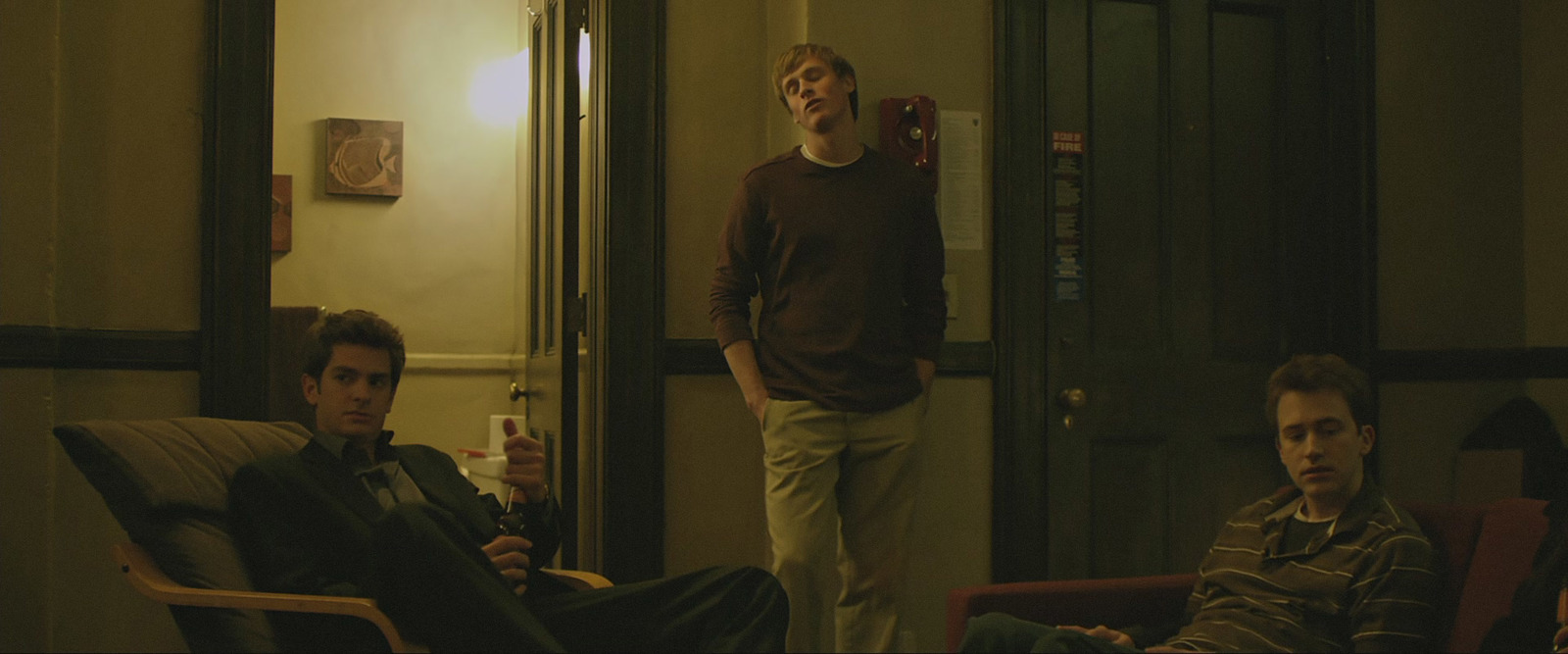 a group of young men sitting around a living room