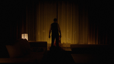 a man standing in front of a window in a dark room