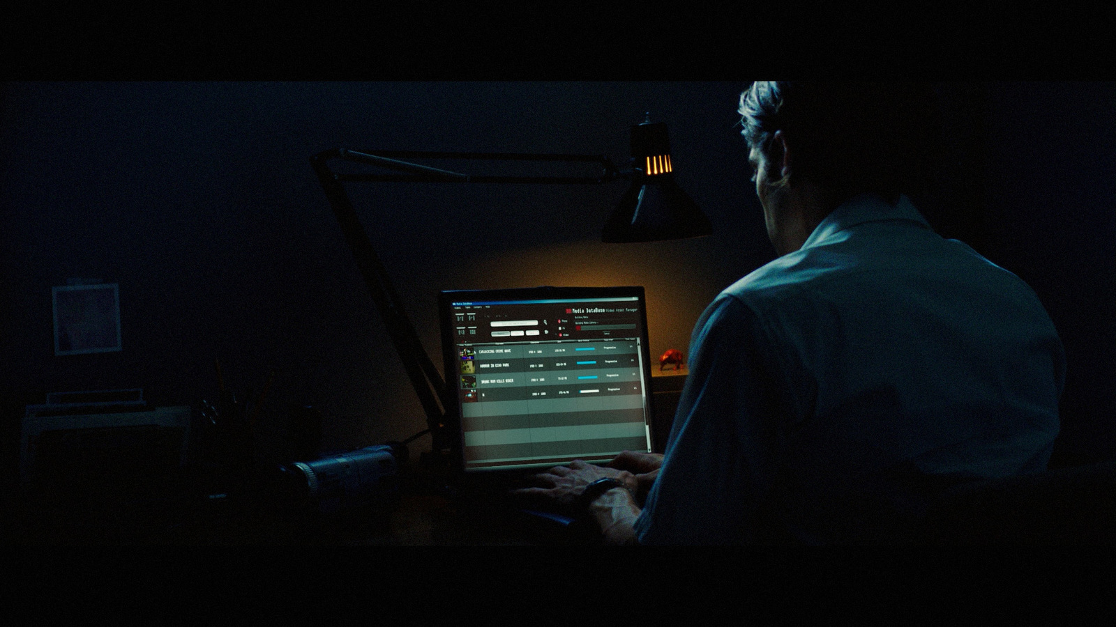 a man sitting in front of a computer in a dark room