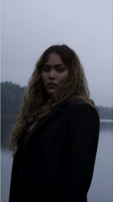 a woman standing in front of a body of water