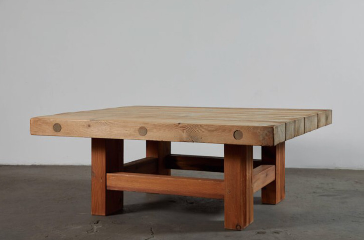 a wooden table sitting on top of a cement floor