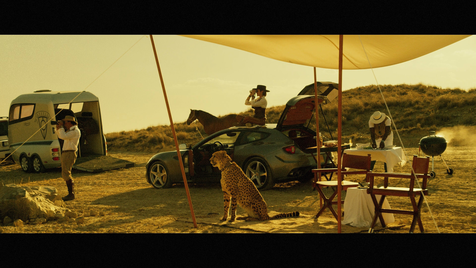 a group of people standing around a car in the desert