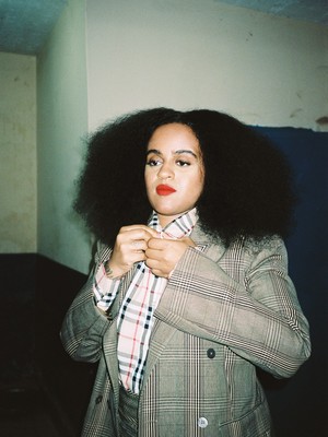 a woman wearing a suit and tie with long hair