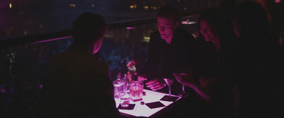 a group of people standing around a table