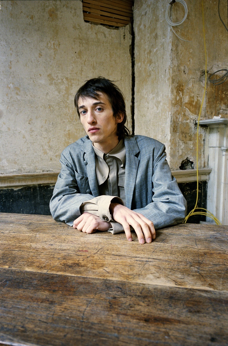 a man sitting at a wooden table in a room