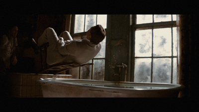 a man laying on a bathtub in front of a window