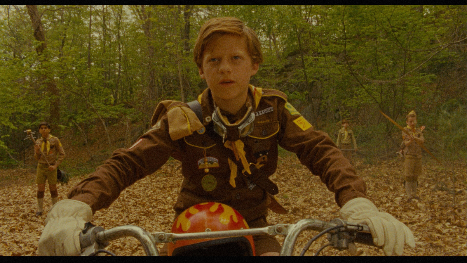 a young boy riding a motorcycle in the woods