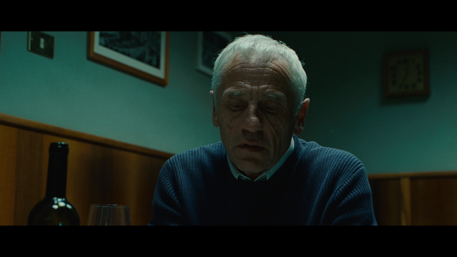 a man sitting at a table with a glass of wine