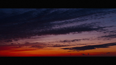 a plane flying in the sky at sunset