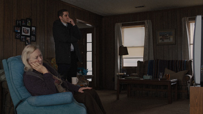 a woman sitting in a blue chair in a living room