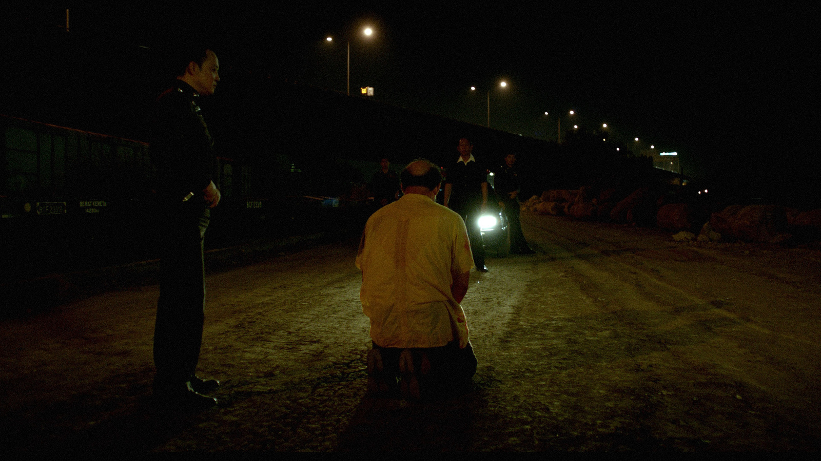 a group of people standing on a dirt road at night