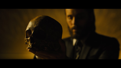 a man in a suit holding a human skull