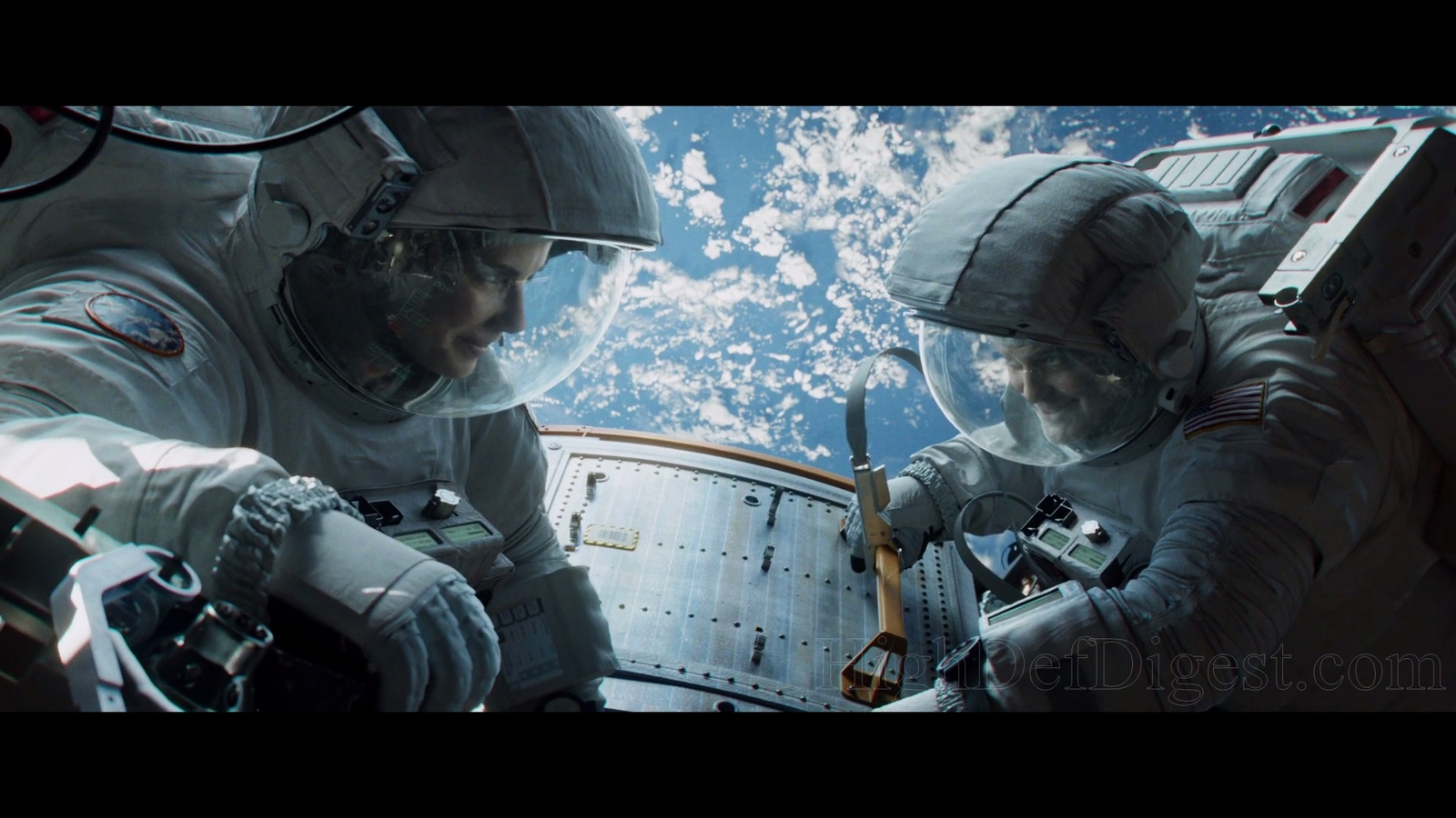 two men in spacesuits are looking at something