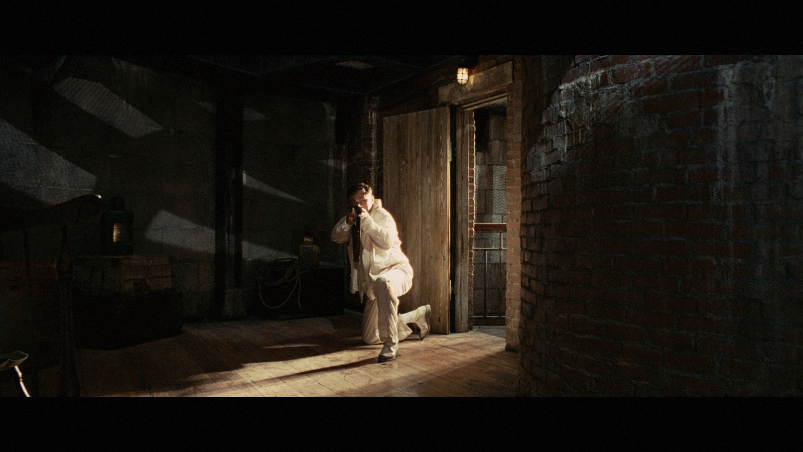 a man standing in a room next to a brick wall