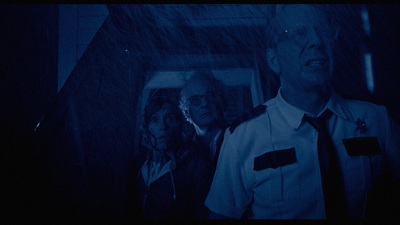 a man standing next to a woman in a dark room