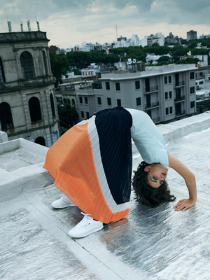 a woman is upside down on the roof of a building