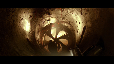 a man standing in a dark tunnel next to a pipe