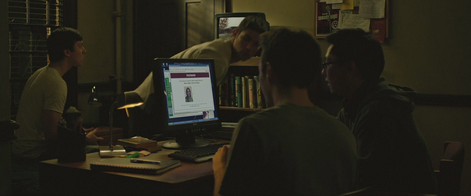 a group of people sitting around a computer