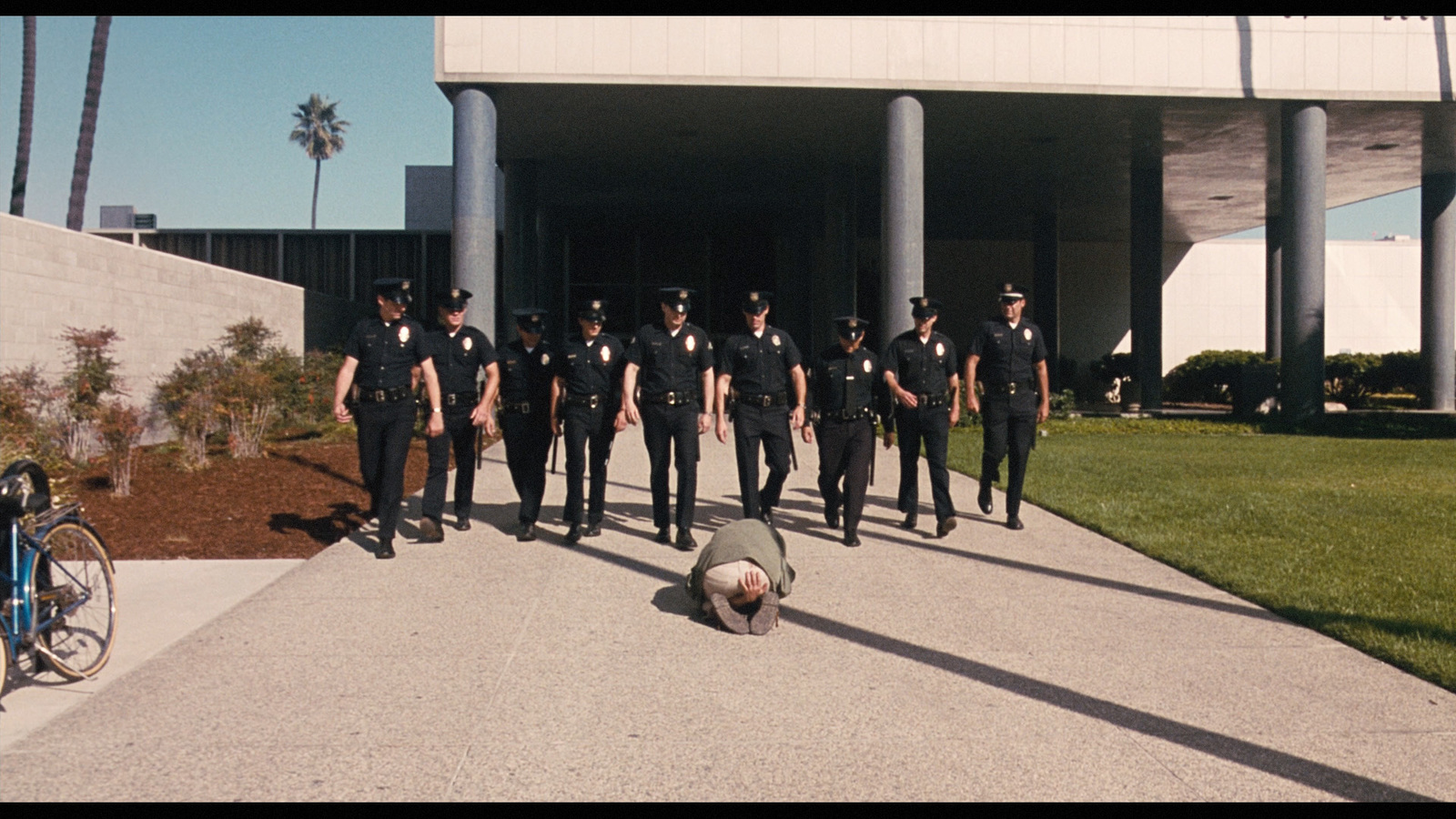 a group of police officers walking down a sidewalk