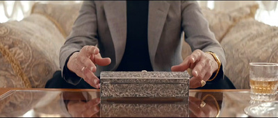 a person sitting at a table with a silver box