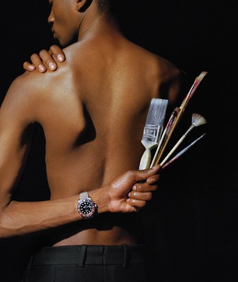 a man holding a bunch of paint brushes