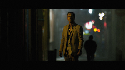 a man in a suit and tie standing in a dark room