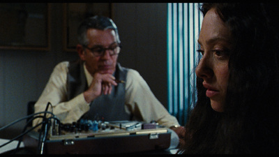 a man and a woman sitting at a table in front of a microphone