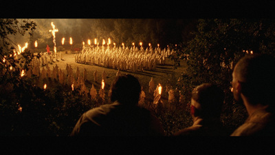 a group of people standing in front of a forest filled with candles