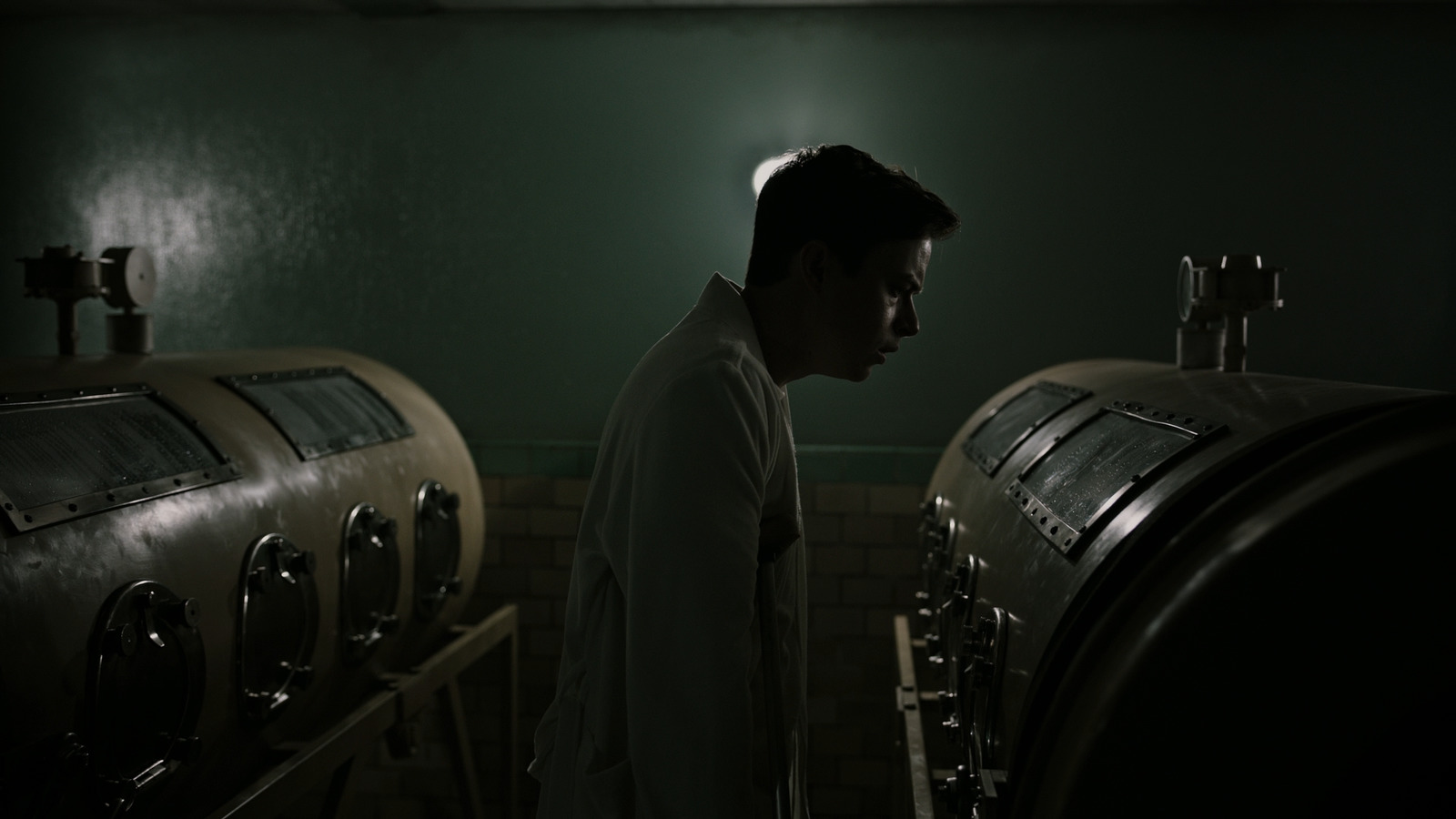 a man standing in front of a row of wooden barrels