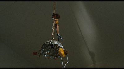 a doll hanging from a chain with a bag on it