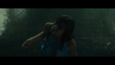 a woman in a blue dress standing in the rain