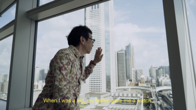 a man standing in front of a window looking out at a city