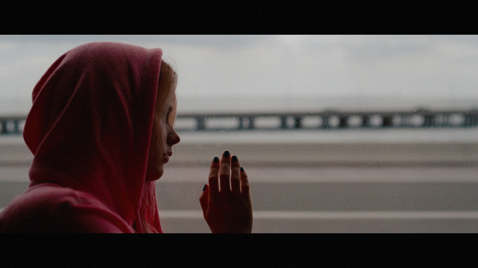 a woman in a red headscarf looking out a window