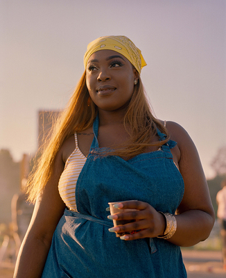 a woman in overalls holding a cup of coffee