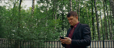 a man in a suit looking at his cell phone