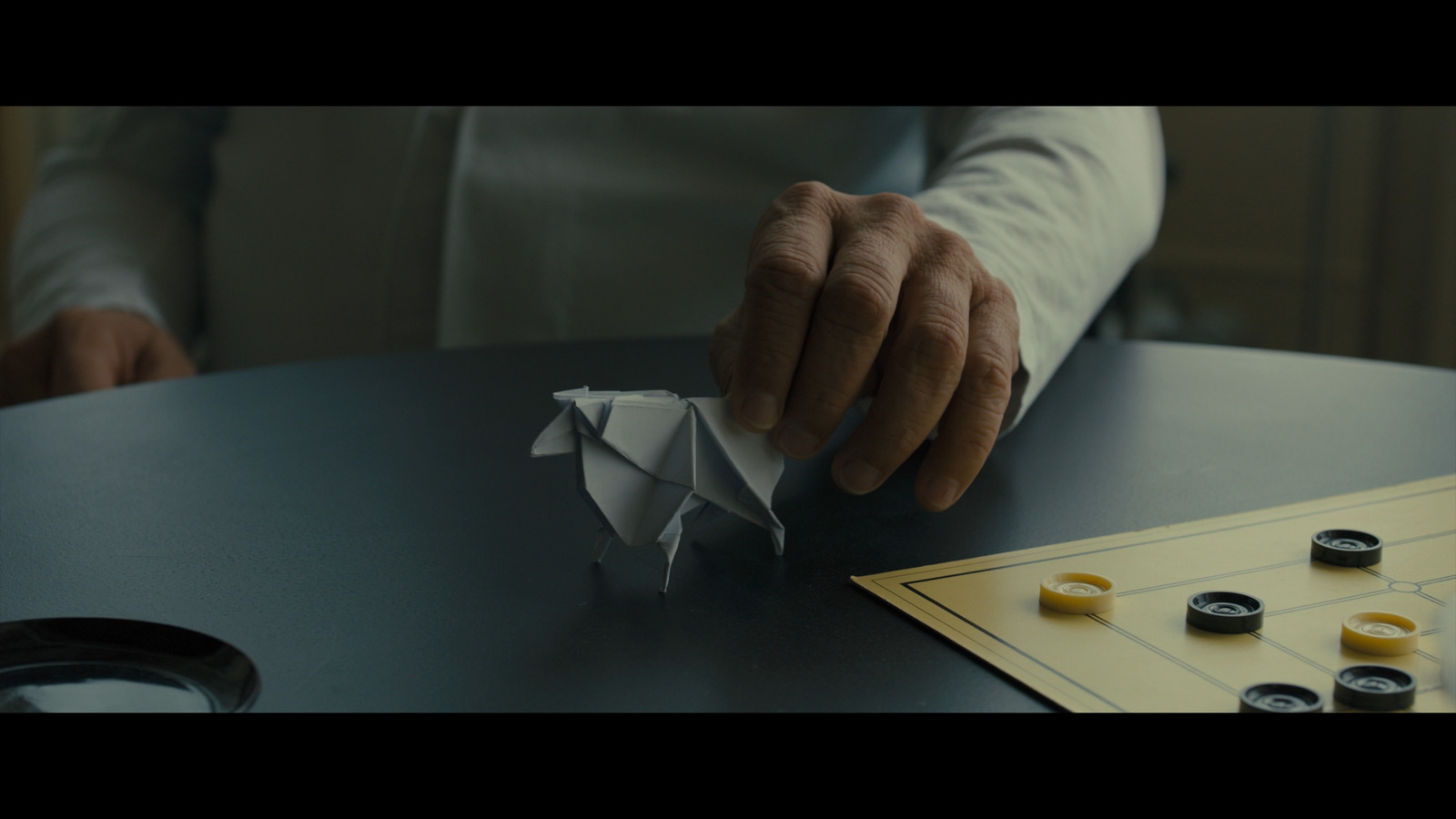 a person holding a piece of paper on top of a table