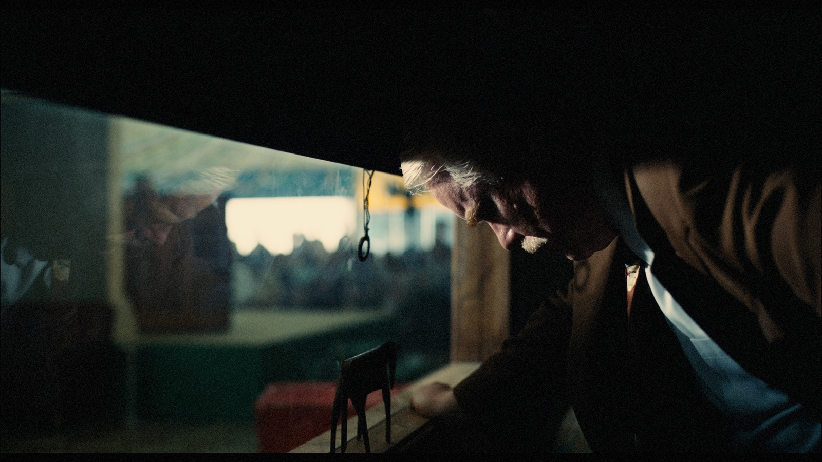 a man in a suit and tie looking through a window