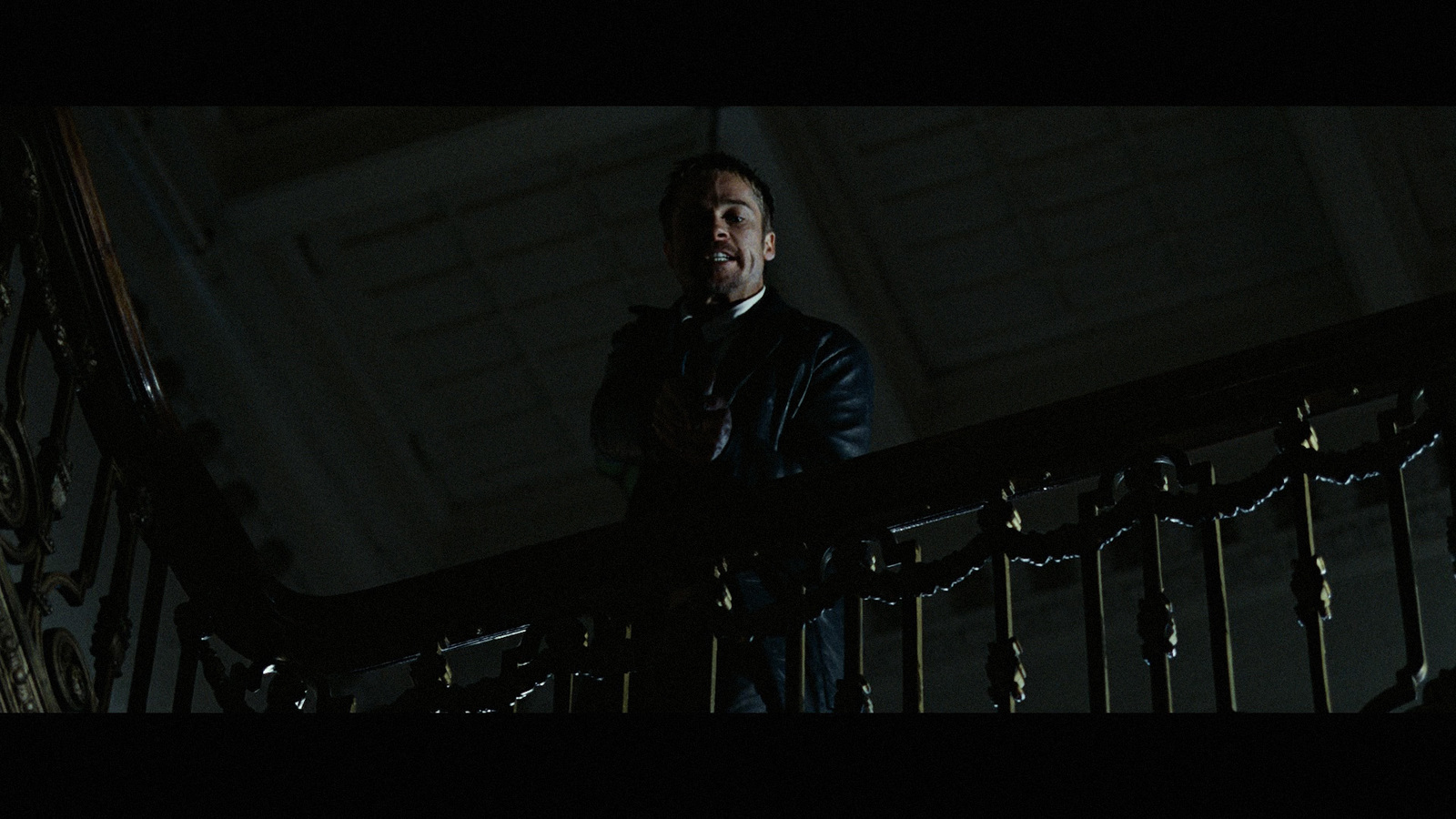 a man standing on a balcony in the dark