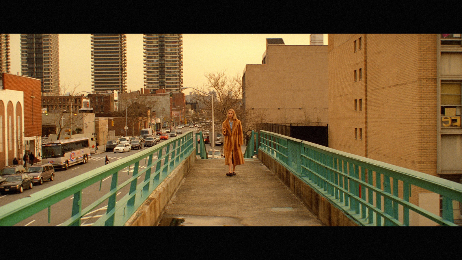 a woman walking across a bridge in a city