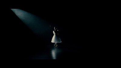 a woman in a white dress standing under a spotlight