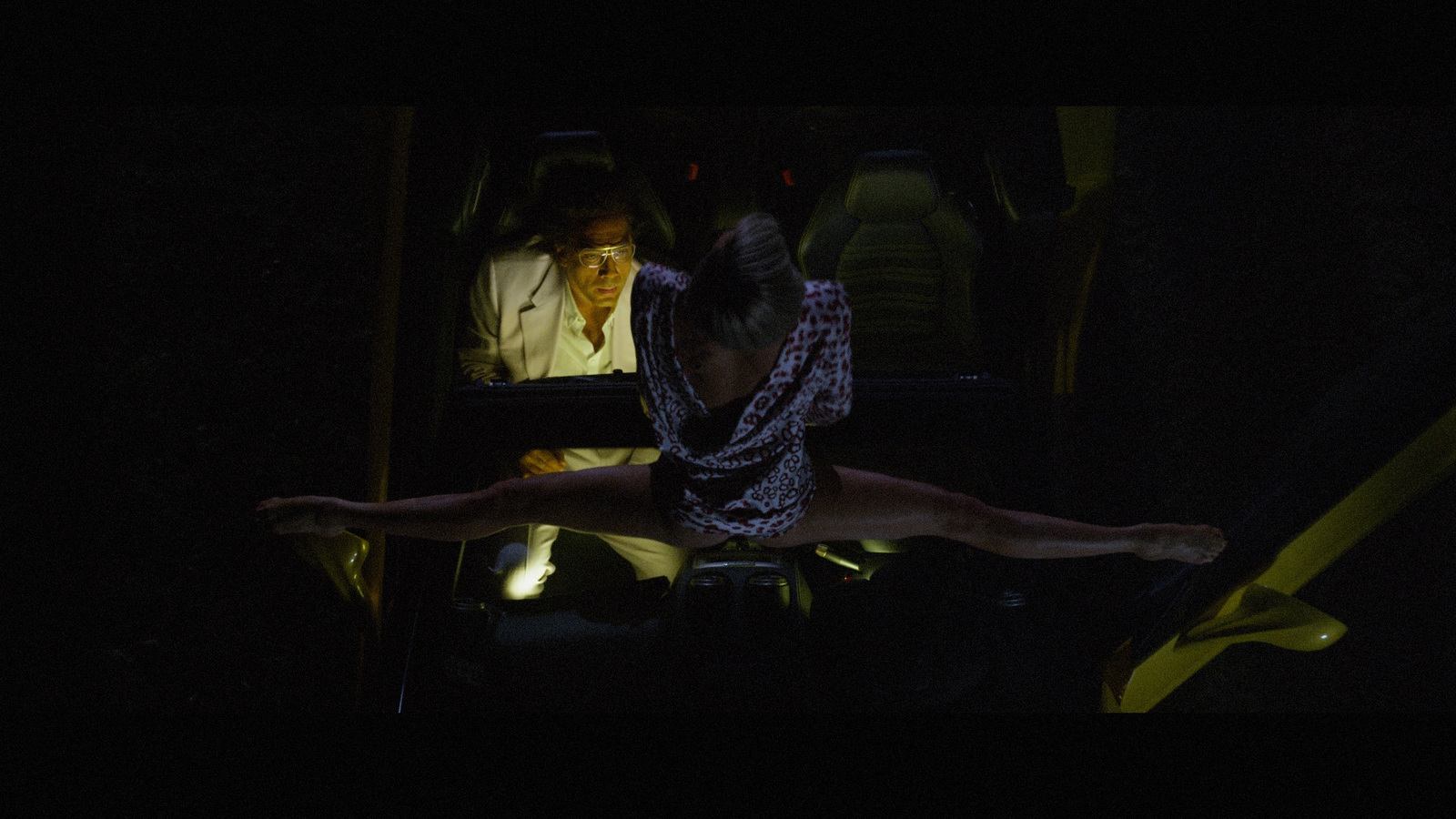 a woman doing a trick on a chair in the dark