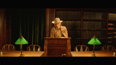 a woman wearing a cowboy hat standing at a podium