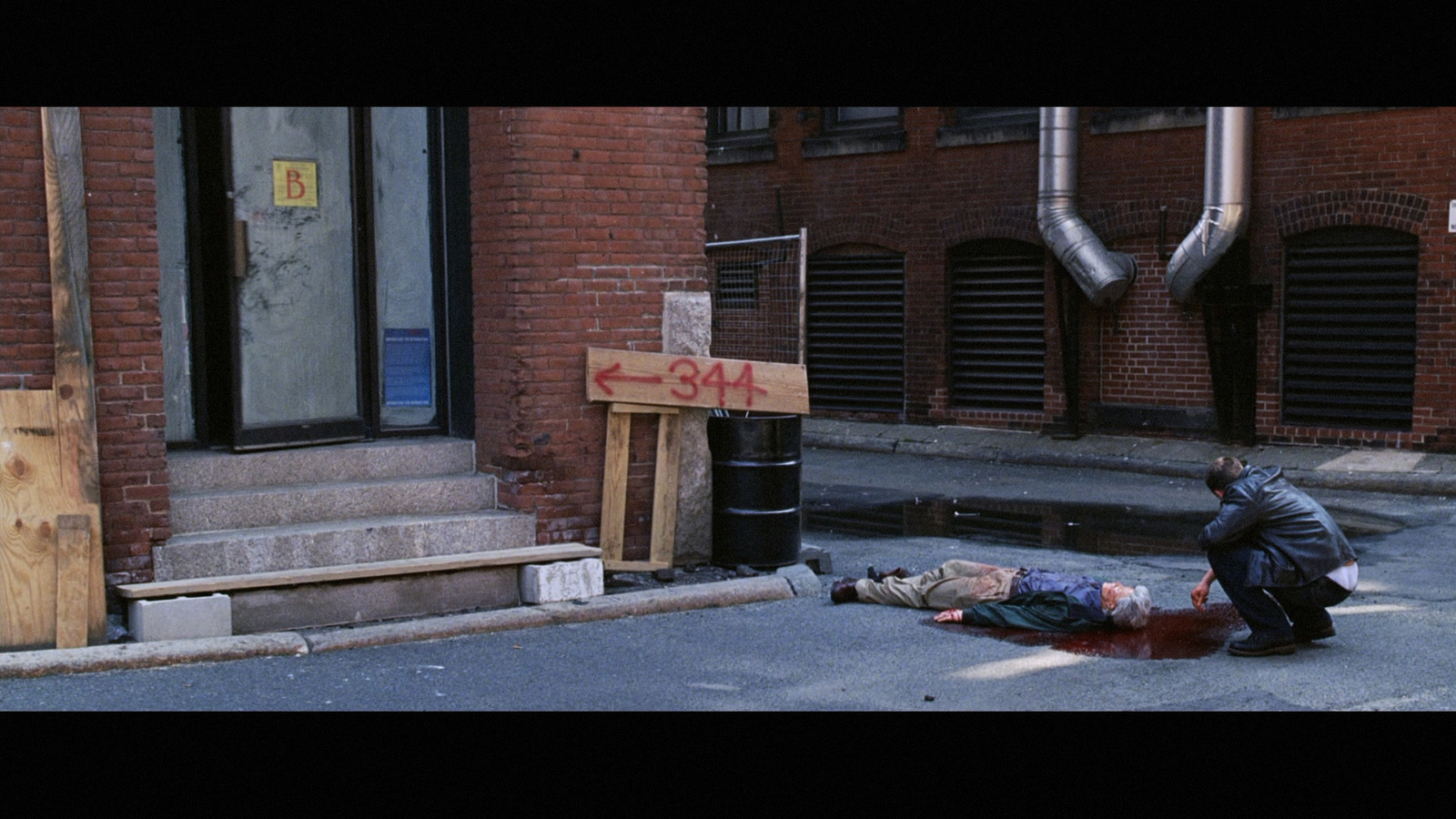 a person laying on the ground in front of a building