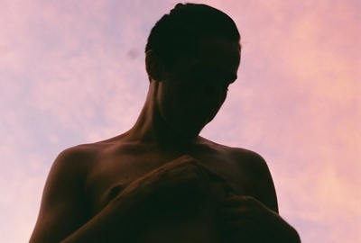 a man standing in front of a pink sky